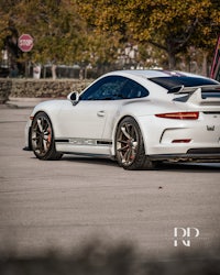 a white porsche 911 gtr parked in a parking lot